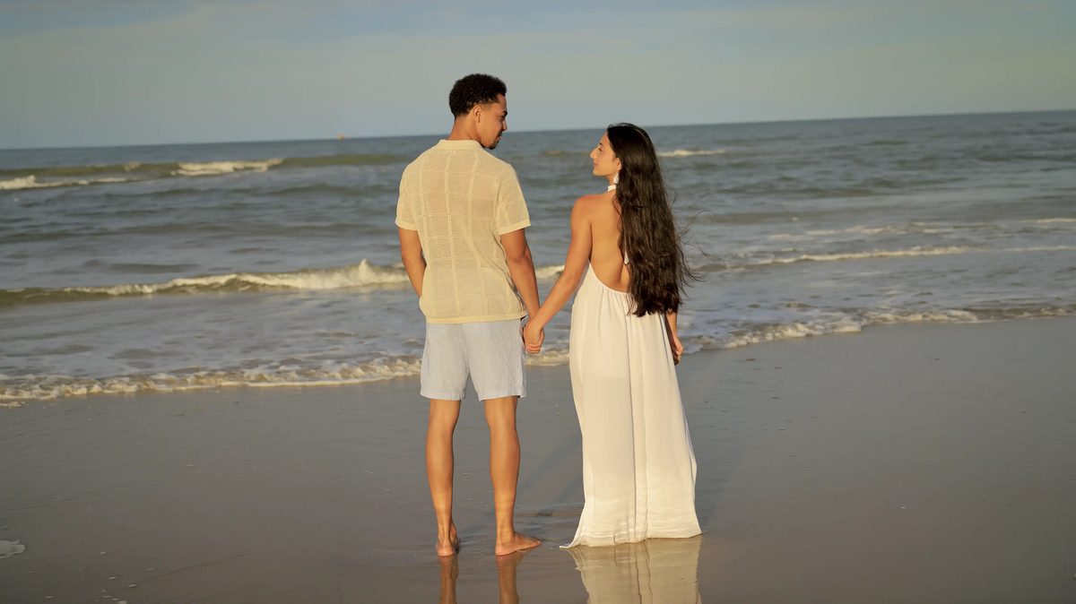 Samuel e Kamilly de mãos dadas, à beira-mar